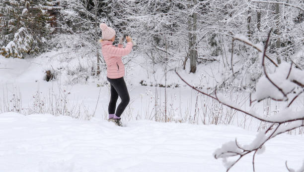 istock Female hiker relaxes by snowy river bank 1214096828