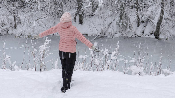 istock Female hiker relaxes by snowy river bank 1214096878