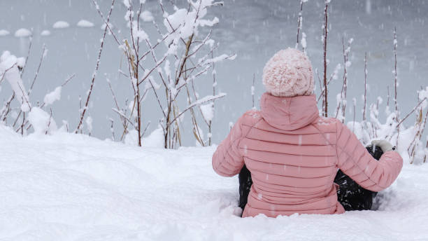 istock Female hiker relaxes by snowy river bank 1214096926