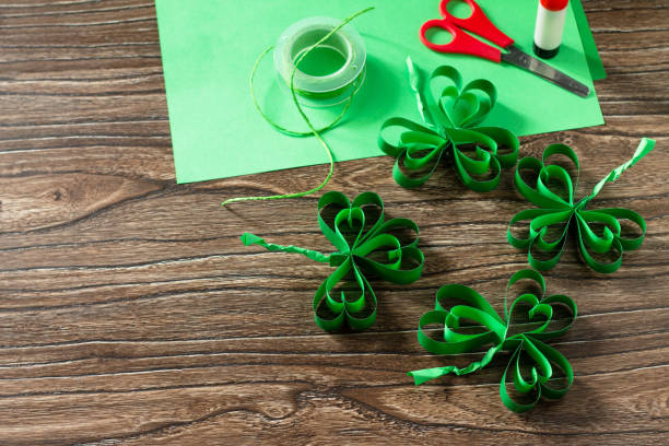 istock Patrick's Day Clover, craft paper on wooden table. Handmade. Children's art project, needlework, crafts for children. 1214097208