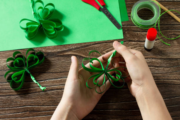 istock Child holds St. Patrick's Day clover, craft from paper. Handmade. Children's art project, needlework, crafts for children. 1214097213