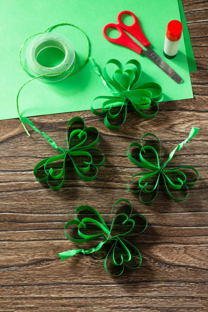 istock Patrick's Day Clover, craft paper on wooden table. Handmade. Children's art project, needlework, crafts for children. 1214097234