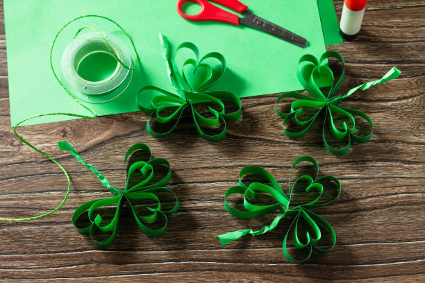 istock Patrick's Day Clover, craft paper on wooden table. Handmade. Children's art project, needlework, crafts for children. 1214097242