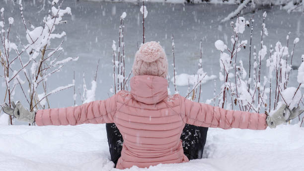 istock Female hiker relaxes by snowy river bank 1214097295