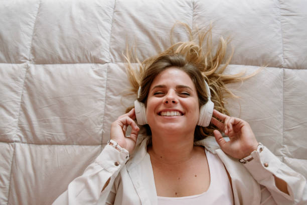 istock girl smiling while listening music on bedroom 1214097429