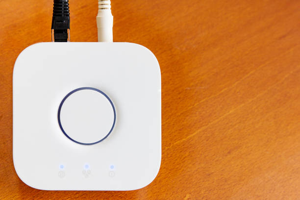 Smart Home Hub in white for home automation on brown  wooden desktop with copyspace.