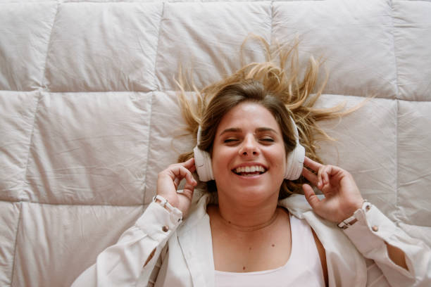 istock white young girl smiling with white headphones 1214098255