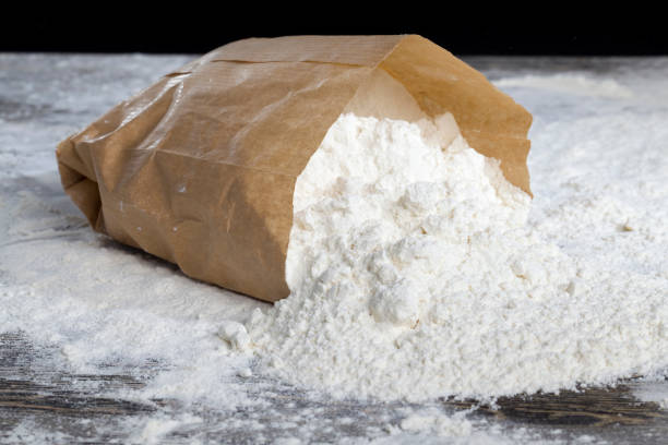 small bag with flour a small paper bag with durum wheat flour on the table, some of the flour powder spilled out of the bag mini wheat cereal stock pictures, royalty-free photos & images
