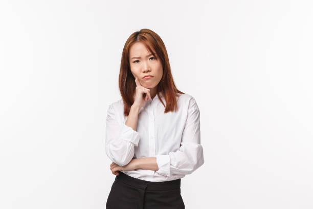 istock Thoughtful and serious grumpy young asian woman thinking, having troubles with making-up plan, lean on hand frowning and staring annoyed camera, standing offended or distressed 1214098427