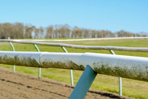 shallow focus of a professional horse racing track shown the lightweight tubular fencing near an ascending curve. - ascot imagens e fotografias de stock