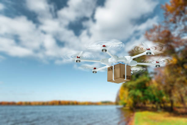 istock White flying drone with a cardboard box on a sky background. drone for delivery. The concept of fast delivery, technology. copy space. 1214100013