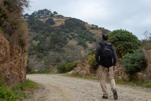 istock Man walking along a Ceuta road with the lighthouse in the background-2 1214101270