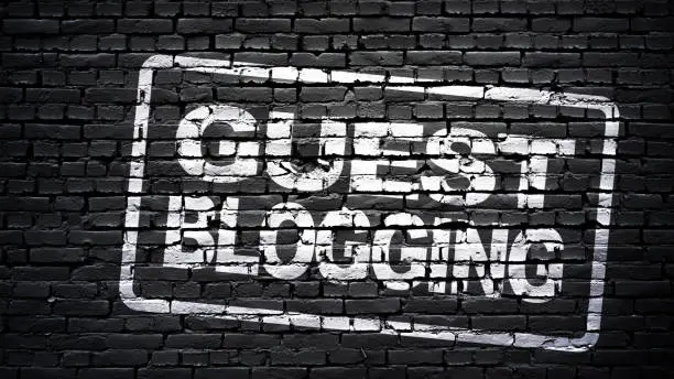 Guest blogging sign, white text on black brick wall