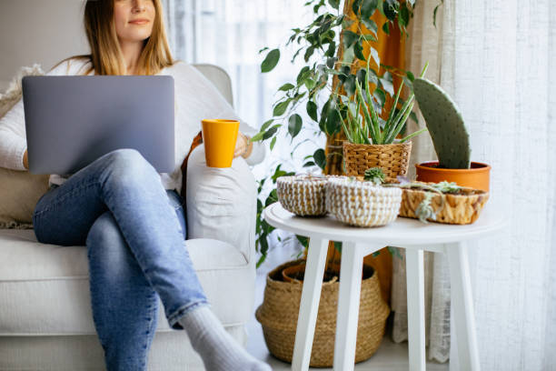 istock Happy smiling woman sitting on sofa and using laptop 1214103770