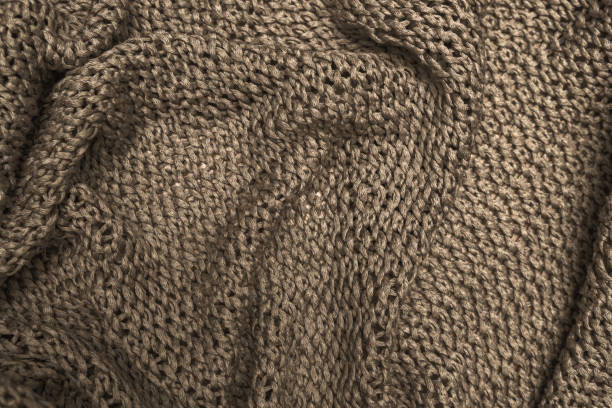 istock Crumpled folded brown knitted fabric background, woolen knitwear close up 1214105529