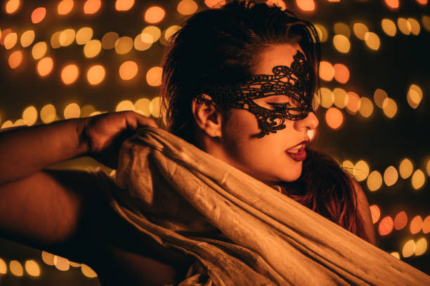 Lady With Venetian Mask Portrait of seductive lady With Venetian Mask and lights in the rear. Sensual Sleep Masks stock pictures, royalty-free photos & images