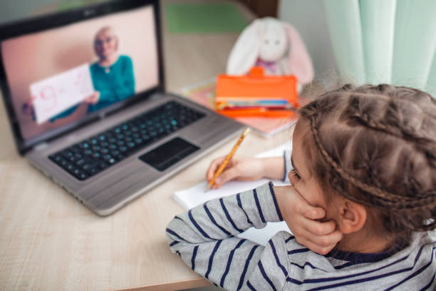 istock Pretty stylish schoolgirl studying math during her online lesson at home, self-isolation 1214106787