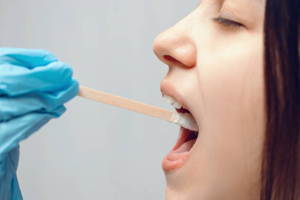 istock Taking a medical sample - a throat swab for a coronavirus test. A nurse's hand takes a sample from a young woman 1214107819