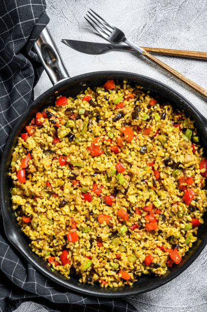 istock Cooked bulgur with vegetables and chicken meat in a pan. Gray background. Top view 1214109462