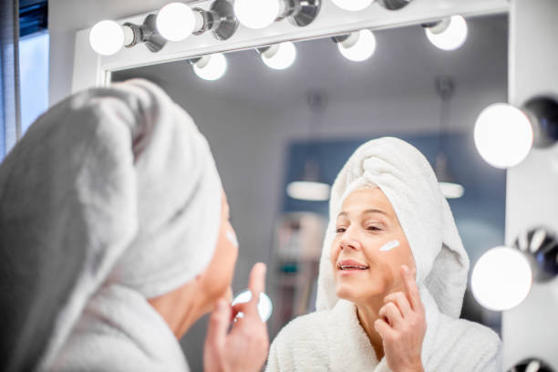 istock Mature woman applying face cream. 1214109825