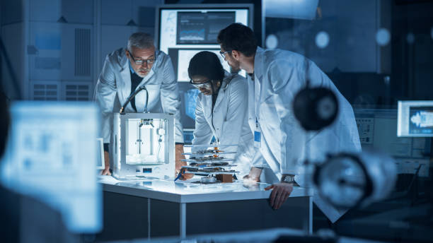 istock In Technology Research Laboratory: Diverse Team of Industrial Scientists, Engineers, Developers Work with Digital Whiteboard Showing Engine Blueprints, Efficiency Calculated by Neural Network 1214111320