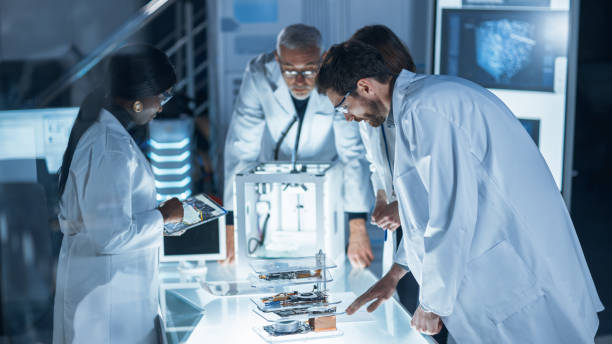 istock In Technology Research Laboratory: Diverse Team of Industrial Scientists, Engineers, Developers Work with Digital Whiteboard Showing Engine Blueprints, Efficiency Calculated by Neural Network 1214111321