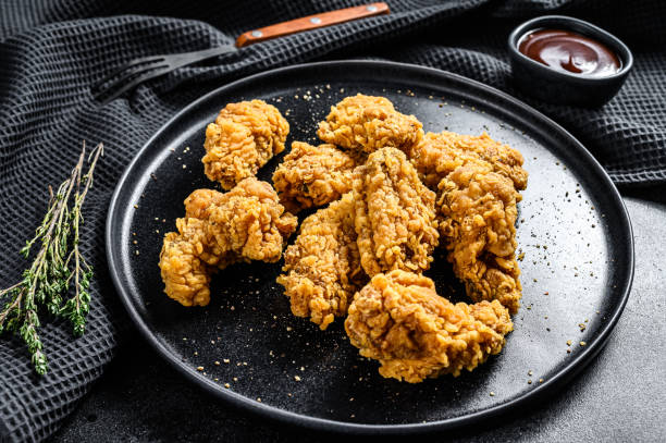 istock homemade baked crispy chicken wings.  Black background. Top view 1214111346