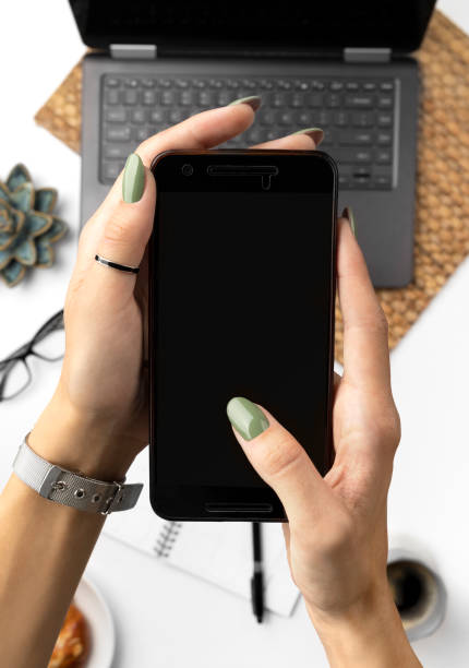 istock Womens hand with green spring summer manicure holding smartphone 1214116546