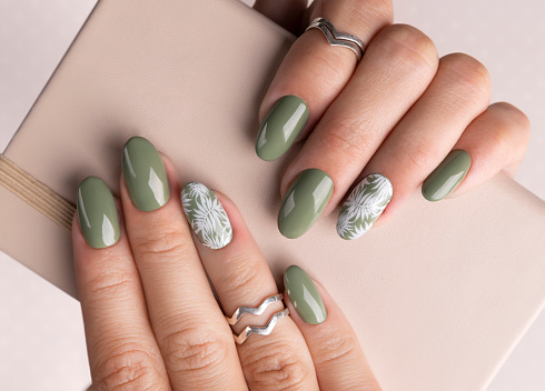 Hermosas manos de las mujeres con el diseño de uñas florales de primavera verano photo