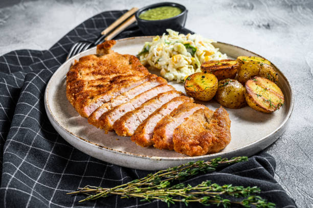 homemade breaded german weiner schnitzel with potatoes and salad.  gray background. top view - weiner schnitzel imagens e fotografias de stock