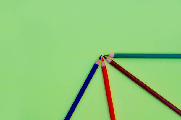 istock Different colored pencil crayons arranged in a quarter circle on a light green paper background 1214117986