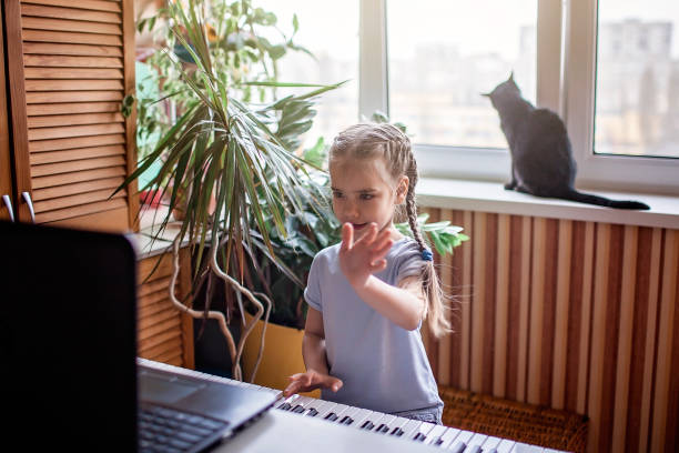 집에서 온라인 수업 중 집에서 클래식 디지털 피아노를 연주하는 젊은 음악가, 자기 고립 - music learning child pianist 뉴스 사진 이미지