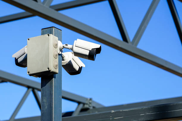 a pillar with three surveillance cameras on the construction site - construction steel construction frame built structure imagens e fotografias de stock