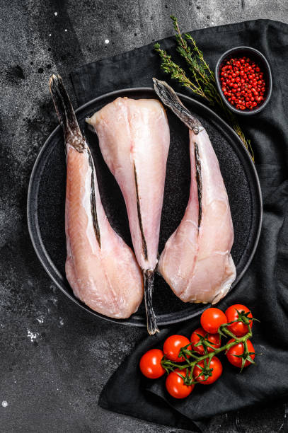 istock Separate fresh monkfish without head and skin. Black background. Top view 1214120487
