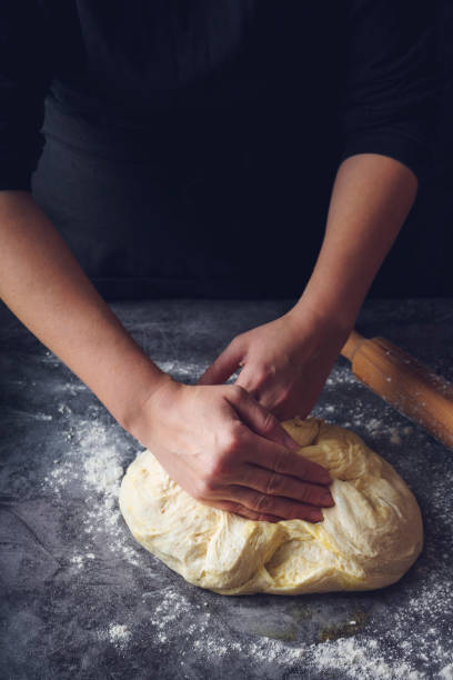 istock Women's hands kneading bread. Food background 1214126260