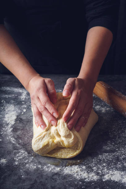 istock Women's hands kneading bread. Food background 1214126299
