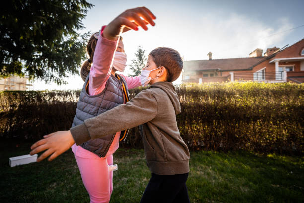 istock Brother and sister playing in back yard during coronavirus home quarantine 1214127345