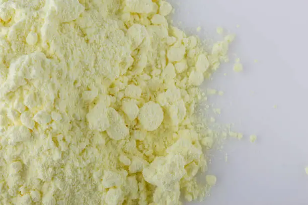 purified sulfur powder on a white acrylic background.