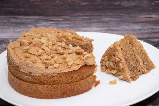 A coffee and walnut cake with a slice removed