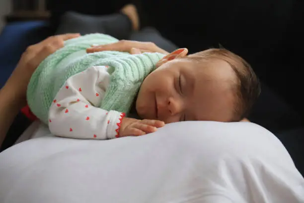 Photo of Baby girl sleeping on her mother's lap