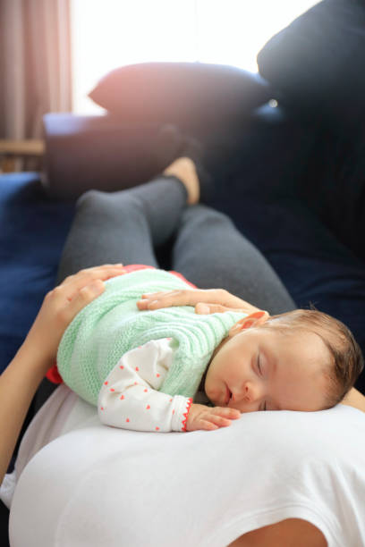 baby girl sleeping on her mother's lap - baby beautiful part of selective focus imagens e fotografias de stock
