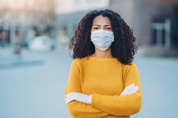 Portrait of a young woman with face mask outdoors in the city Woman wearing a face mask standing outdoors avian flu virus photos stock pictures, royalty-free photos & images