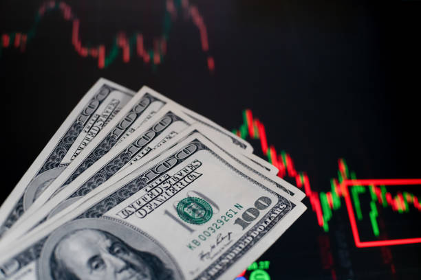istock US dollar bills on background with dynamics of exchange rates. Trading and financial risk concept 1214135202