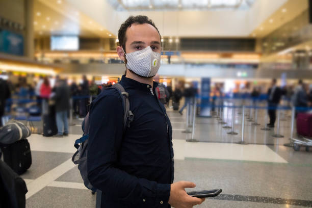 istock Man with face mask at the airport 1214136162