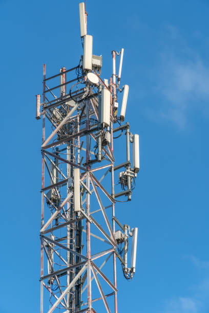 istock Mobile communication tower close-up against the blue sky, vertical photo 1214136250