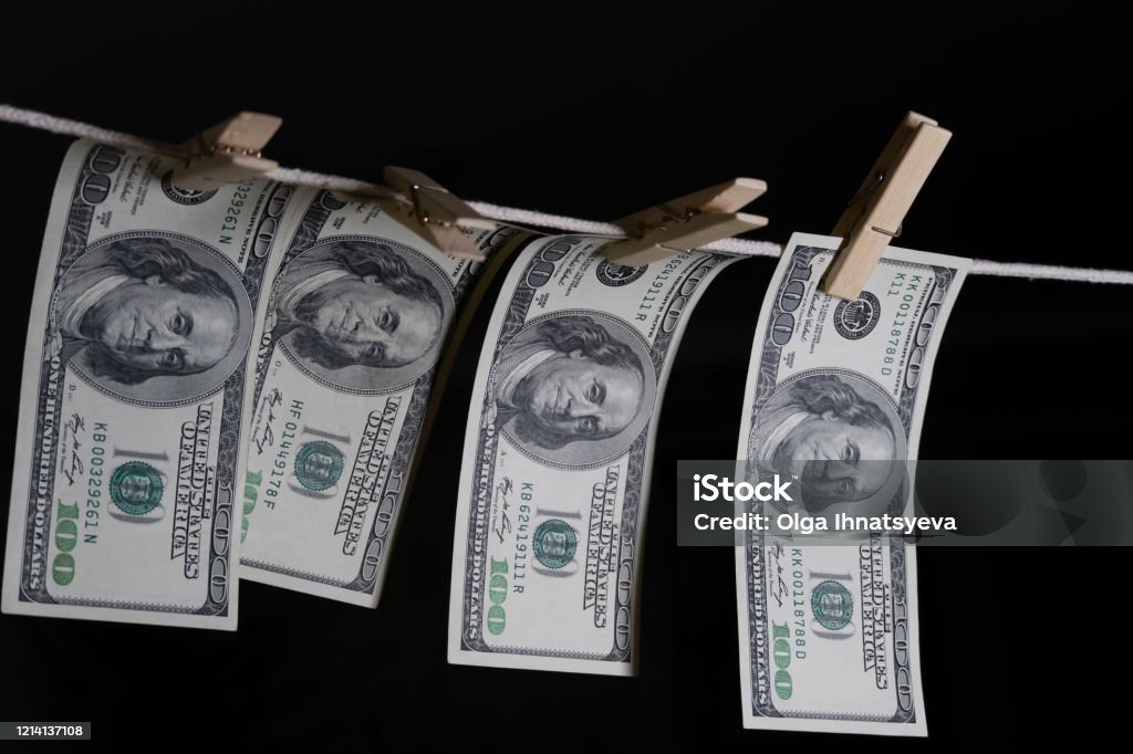 One-hundred dollar bills are hung with clothespins on a string on a black background. concept of dirty money. dollar is falling. Backgrounds Stock Photo