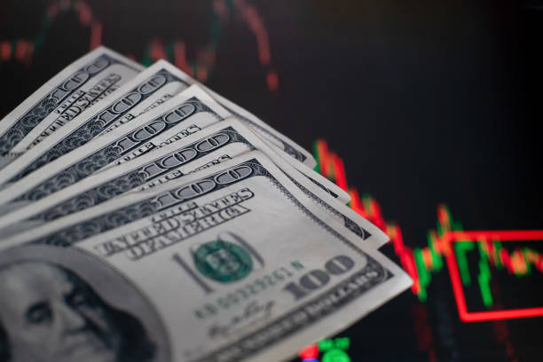 istock US dollar bills on background with dynamics of exchange rates. Trading and financial risk concept 1214137468