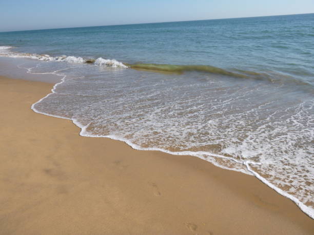 istock Seashore with blue water and white foam 1214140459