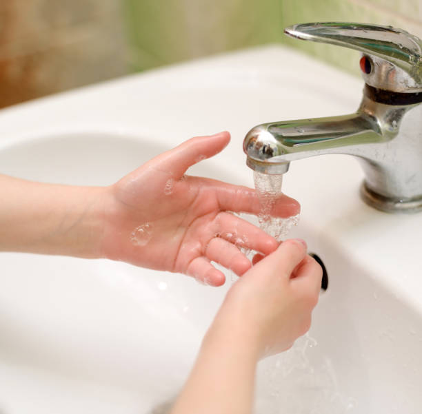 istock child washes hands in bathroom 1214141444