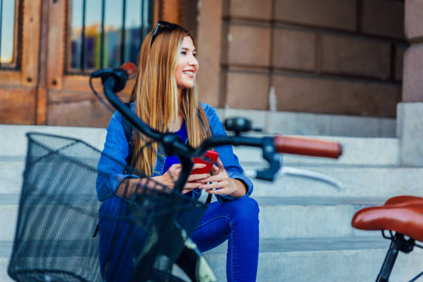 istock Woman using mobile phone after riding bicycle 1214143748